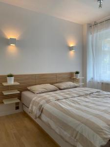 a bedroom with a large bed with a wooden headboard at WHY NOT Apartament w centrum, ul. Gimnazjalna 12/1 in Zakopane