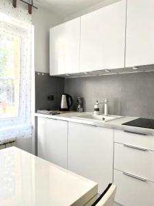 a white kitchen with white cabinets and a window at WHY NOT Apartament w centrum, ul. Gimnazjalna 12/1 in Zakopane