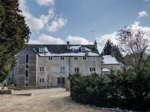 an old stone house with snow on the roof at Arlington Mill in Cirencester