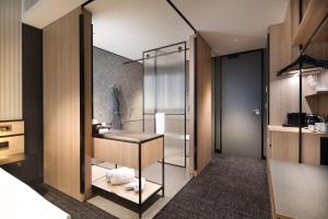 a bathroom with a glass shower and a sink at The Howey in Melbourne