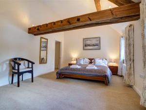 a bedroom with a bed and a wooden ceiling at Arlington Mill in Cirencester