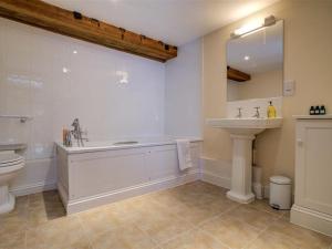 a bathroom with a tub and a toilet and a sink at Arlington Mill in Cirencester