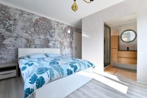 1 dormitorio con cama y pared de ladrillo en Gite des Hirondelles en Ostheim