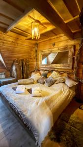 Cama grande en habitación con techo de madera en Gorący Potok Apartamenty, en Szaflary