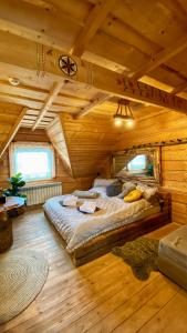 a bedroom with a large bed in a wooden cabin at Gorący Potok Apartamenty in Szaflary