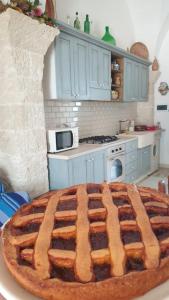 a large pie sitting on a table in a kitchen at Masseria Vivi il Salento in Santa Caterina di Nardò