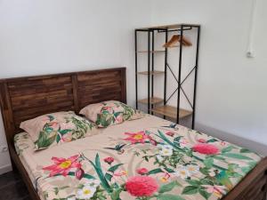 Un dormitorio con una cama con flores. en Ti kaz Vanille, en Saint-Philippe