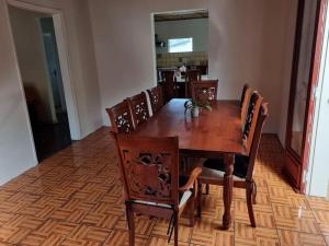 uma mesa de jantar com cadeiras e um piso de madeira em Ti kaz Vanille em Saint-Philippe