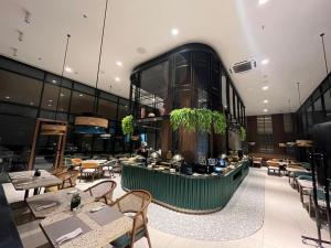 a restaurant with tables and chairs in a building at Herloom Hotel & Residence BSD Tangerang in Tangerang