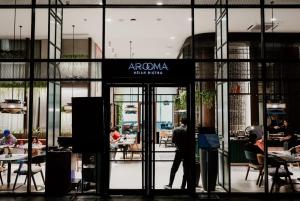 a man walking into a restaurant with a sign on the door at Herloom Hotel & Residence BSD Tangerang in Tangerang