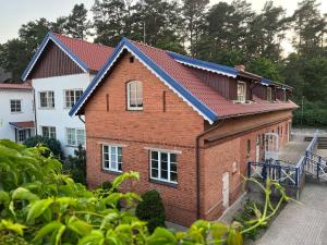 a red brick house with a blue roof at Marių Banga in Nida