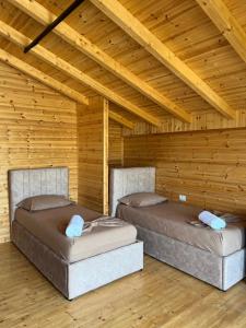 Duas camas num quarto com tectos em madeira em Posh villa 1 em Kavajë