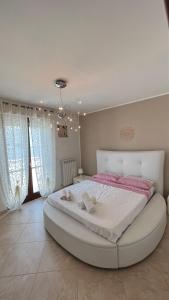 - une chambre avec un grand lit blanc et des draps roses dans l'établissement Msdimorasuite, à Carovigno