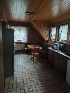 uma cozinha com uma mesa, um lavatório e uma mesa em Appartement am Waldesrand em Gifhorn