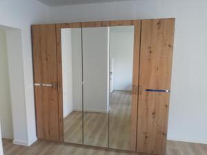 duże szklane drzwi w pokoju z drewnianymi ścianami w obiekcie Maestro I. w mieście Laško