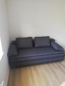 um sofá azul sentado num quarto em Maestro I. em Laško