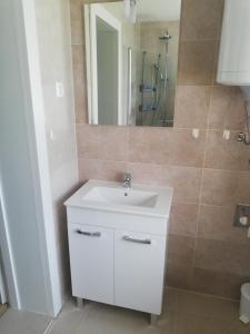 uma casa de banho com um lavatório branco e um espelho. em Maestro I. em Laško