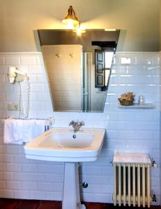 a white bathroom with a sink and a mirror at HOTEL RURAL ARREDONDO in Celorio