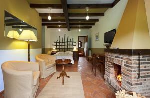 ein Wohnzimmer mit einem Bett und einem Kamin in der Unterkunft HOTEL RURAL ARREDONDO in Celorio