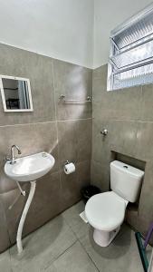 a bathroom with a toilet and a sink at Suíte nº 03 - Praia das Pitangueiras in Guarujá