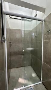 a shower with a glass door in a bathroom at Suíte n° 03 - Praia das Pitangueiras in Guarujá