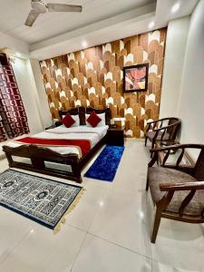 a bedroom with a bed and two chairs and rugs at Hotel Vista Inn, Karol Bagh, New Delhi - Near Metro in New Delhi