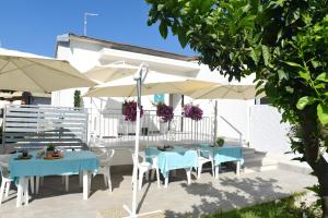 een patio met tafels en parasols in een tuin bij Luna Calante in Santa Maria di Castellabate