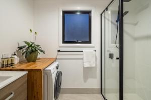 baño con lavadora y ventana en Blyth Retreat, Bruny Island en Simpsons Bay