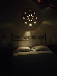 Una cama en una habitación oscura con una luz sobre ella en casadipaola, en Gambassi Terme