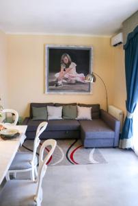 una sala de estar con sofá y una pintura en la pared en Il Nido di Nonna Zita, en Torre del Lago Puccini