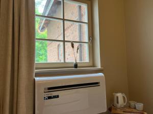 a window above a heater in a room at Marių Banga in Nida