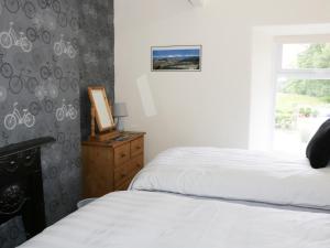 um quarto com 2 camas individuais e uma janela em Camellia Cottage em Bowness-on-Windermere
