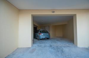 un coche aparcado en un aparcamiento vacío en Coconut Tree House with port view en Zakynthos