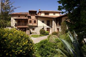 a large house with a garden in front of it at HOTEL RURAL ARREDONDO in Celorio