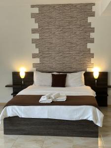 a bedroom with a large bed with two towels on it at Къща за гости Golden Reef in Tsarevo