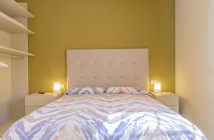 a bedroom with a bed with two lights on both sides at Vive Tarragona in Tarragona