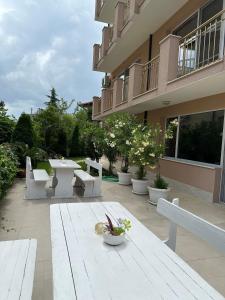 un patio avec une table et des bancs en face d'un bâtiment dans l'établissement Къща за гости Golden Reef, à Tsarévo