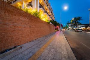 an empty street at night with a brick wall at Royal Crown Hotel & Spa in Siem Reap
