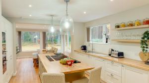 a kitchen with white cabinets and a wooden counter top at Dalnaglar in Nethy Bridge