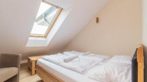 una camera da letto con un letto con lenzuola bianche e una finestra di Baltic Garden, Sun & Snow a Sztutowo Altre 16 foto