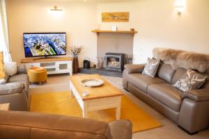 a living room with a couch and a tv at Longfield, Daviot in Inverness