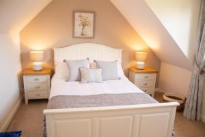 a bedroom with a white bed with two night stands at Longfield, Daviot in Inverness
