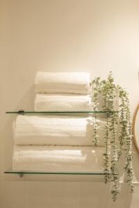 four towels on a glass shelf in a bathroom at Dalnaglar in Nethy Bridge