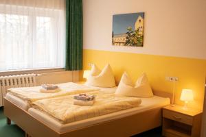 two beds in a room with yellow walls at Sächsisches Gemeinschafts-Diakonissenhaus ZION e. V. in Aue