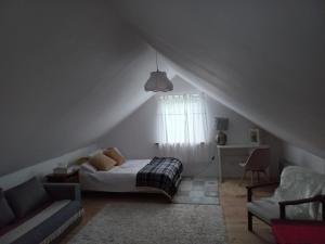 1 dormitorio con cama, sofá y ventana en Domek JÓZEFA przy ZAMKU, en Janów Podlaski