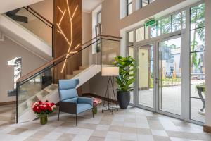 hol ze schodami i niebieskim krzesłem w obiekcie STORIES Design ApartHotel w Jurmale