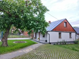 una casa con techo rojo y un árbol en Domek JÓZEFA przy ZAMKU, en Janów Podlaski