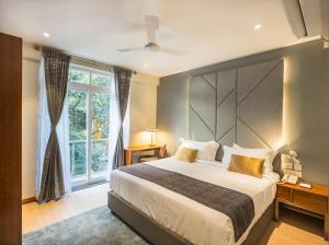 a bedroom with a large bed and a large window at De Mandarin in Bangalore