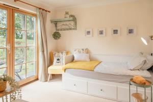 a bedroom with a bed and a large window at Balnagowan Cottage in Nethy Bridge