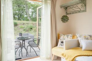 a bedroom with a bed and a patio with a table at Balnagowan Cottage in Nethy Bridge